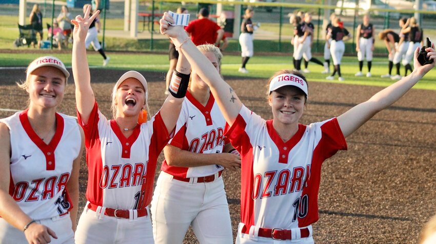 OZARK'S KAYDEN MILLER, ALLIE MUGGENBURG AND KAYLEE LINNEBUR celebrate the Lady Tigers' victory.