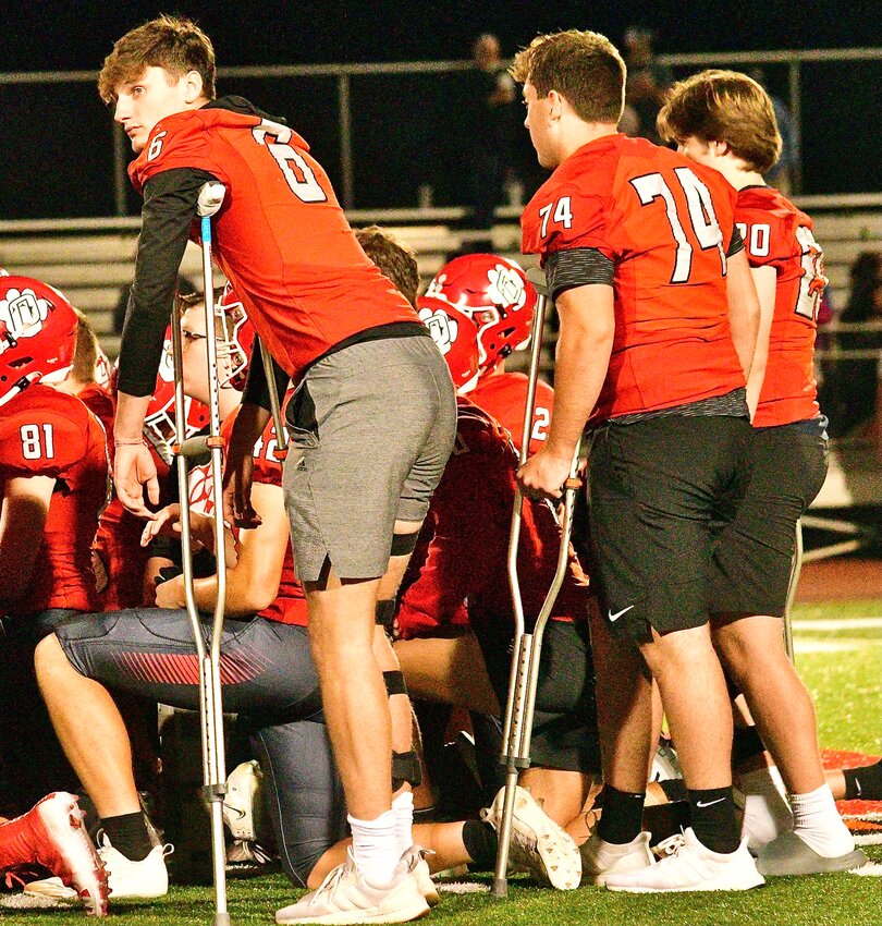 OZARK'S JACE WHATLEY AND LOGAN SMITH lean on their crutches during the Tigers' post-game huddle Friday.