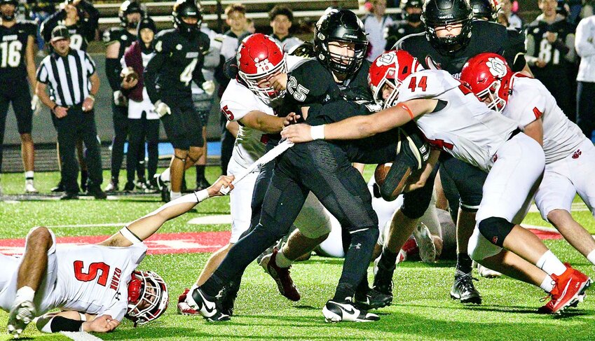 OZARK'S FRANKIE MUNOZ reaches for the towel of a Neosho ball-carrier as Parker Elliott finishes off the tackle Friday.