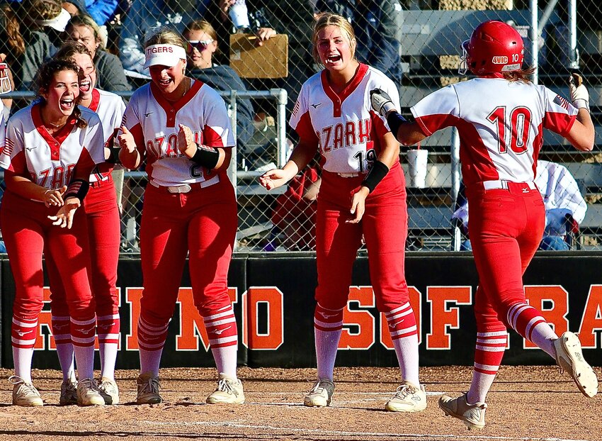 OZARK'S KAYLEE LINNEBUR is met by teammates after hitting a solo home run Thursday.