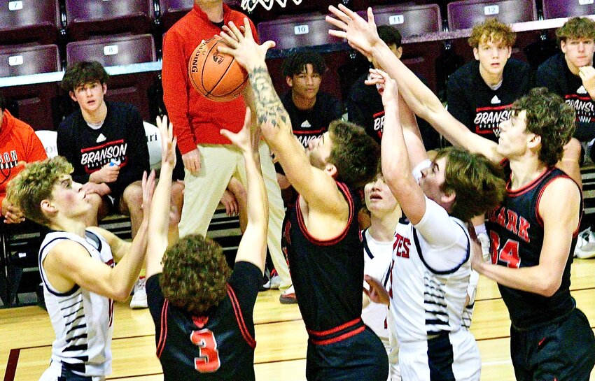 OZARK'S RYAN ENGEL grabs a rebound while surrounded by teammates and Branson players.