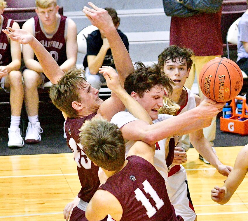 OZARK'S JACE WHATLEY battles for a rebound with Strafford players Thursday.