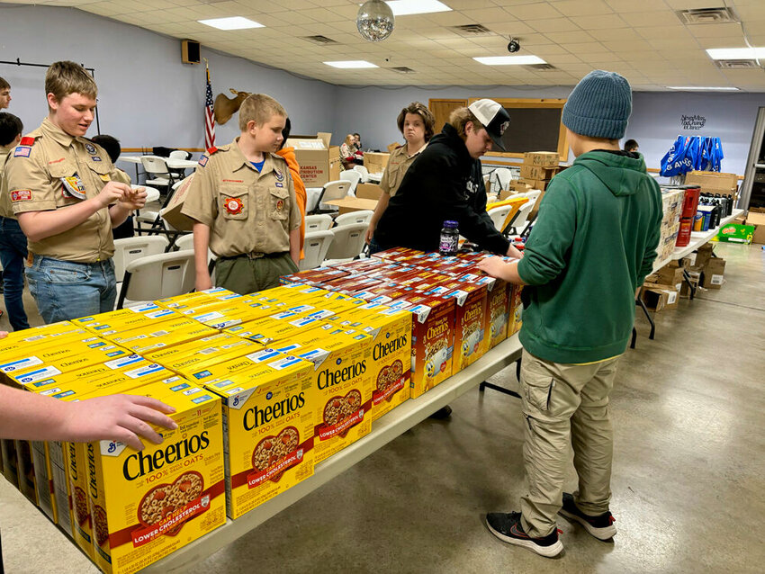 Scout Troop 201 prepares 150 boxes of food.