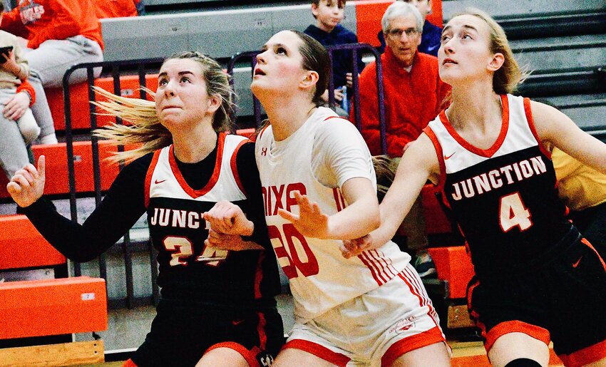 NIXA'S GWEN KUBIK battles for position with two Carl Junction players Thursday.