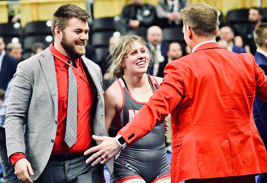 NIXA'S BRENYA CRAHAN receives congrats after winning a state championship from assistant coaches Ben Melton and Josh Downing.