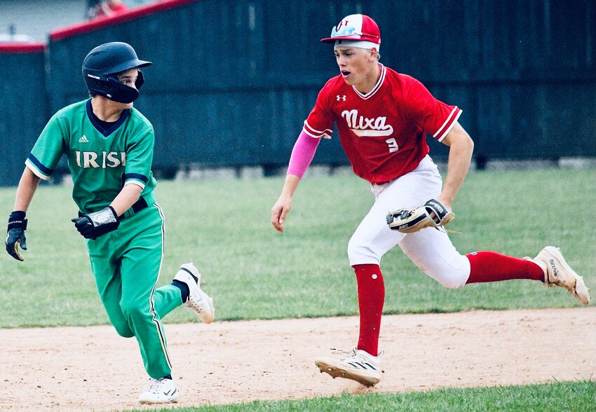 NIXA'S CAEDEN CLOUD gives chase to a Springfield Catholic runner between second base and third base Thursday.