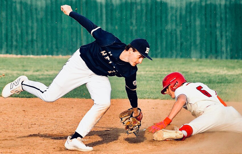 OZARK'S CADEN MCGEHEE keeps a hand on the bag as he steals second base against Jefferson City Helias on Friday.