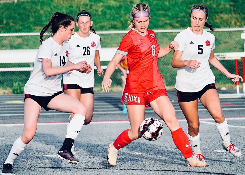 NIXA'S SHAELEE FRANCK controls the ball in the middle of a trio of Ozark players.