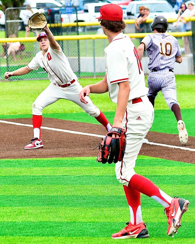 OZARK'S GEORGE REYNOLDS reaches for a throw from Hudson Roberts on a putout at first base.