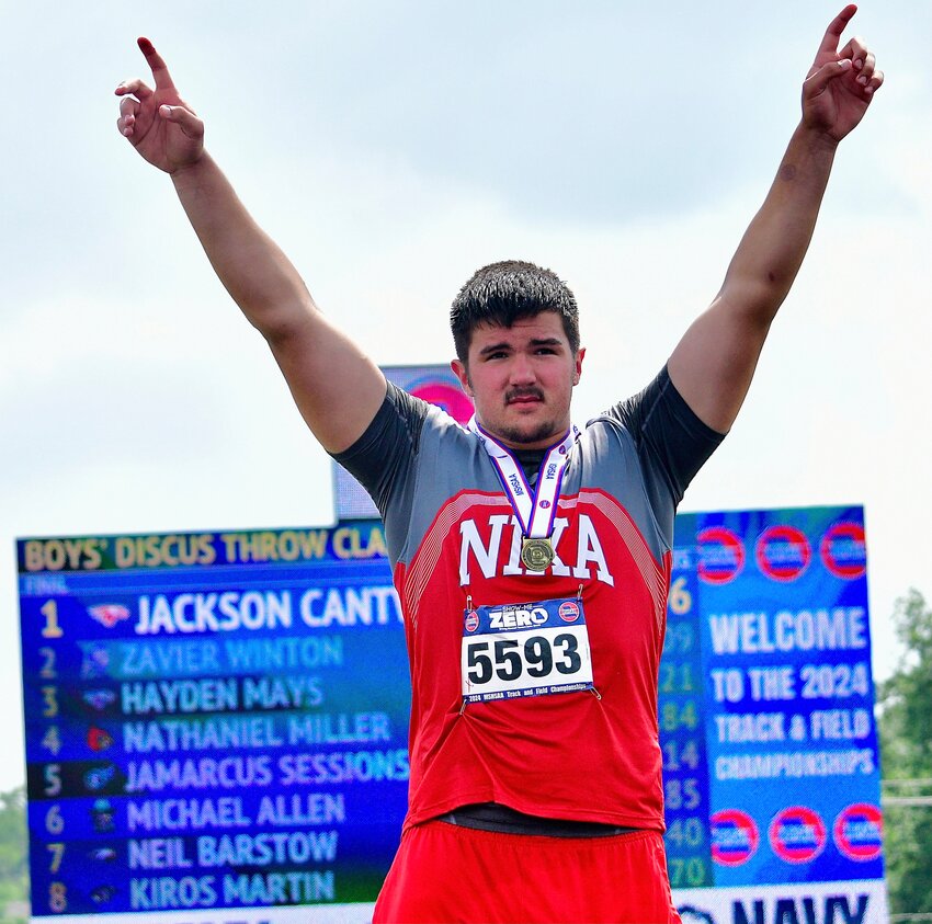 NIXA'S JACKSON CANTWELL raises his arms in celebration after receiving his gold medal in the discus Friday.