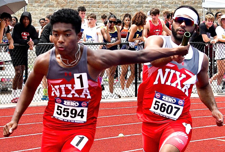 NIXA'S SPENCER WARD AND JAREN DAVIS complete an exchange in the 4 x 200 relay at the Class 5 State Track Meet.