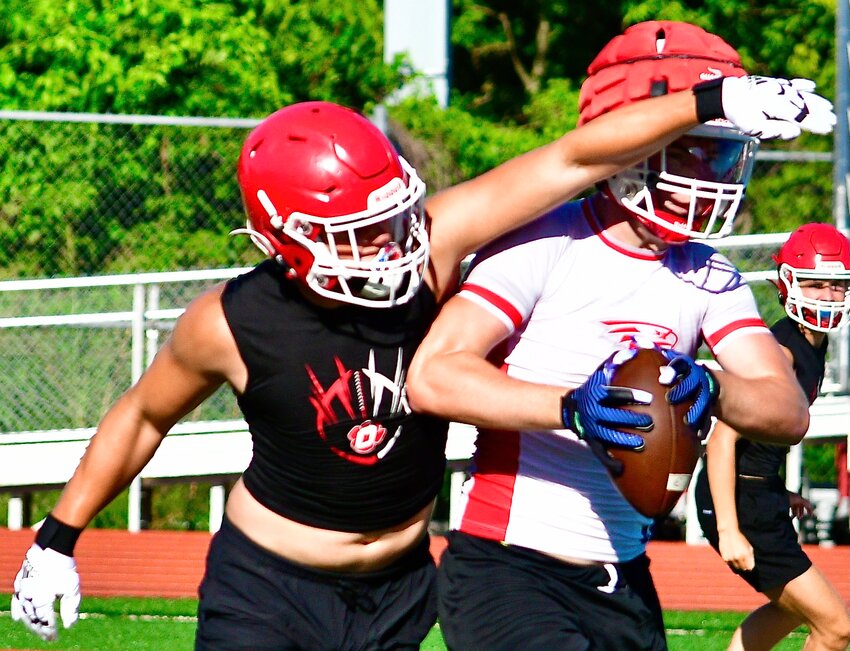 NIXA'S LANE MELTABARGER, right, secures a reception against Ozark in 7-on-7 action.