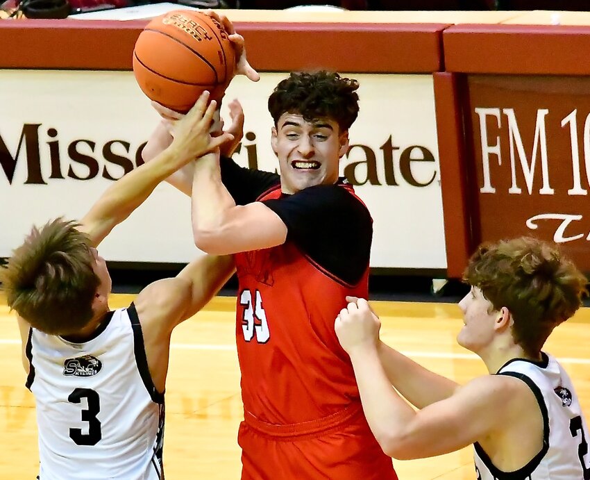 OZARK'S JAXON DUBLIN makes a pass in between two Skyline defenders.