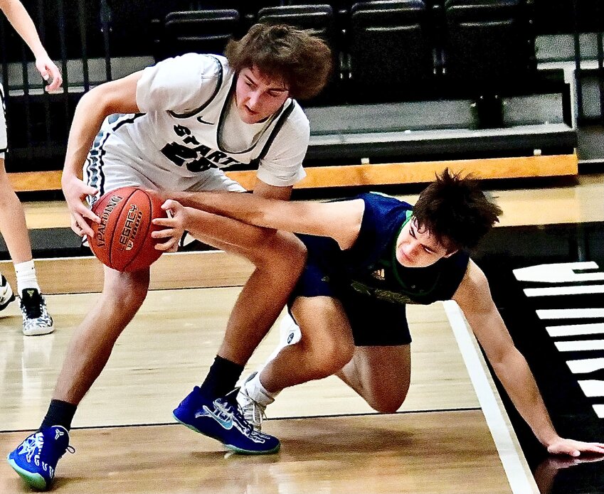 SPARTA'S TRENTON INGLE protects the ball as a Catholic defender tries for a steal in the teams' matchup Thursday.