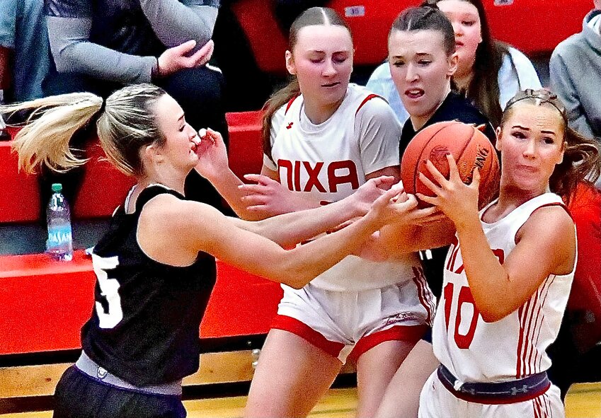 NIXA'S KARIS FERGUSON keeps a tight grip on the ball as she is pressured by Fair Grove defenders Saturday.