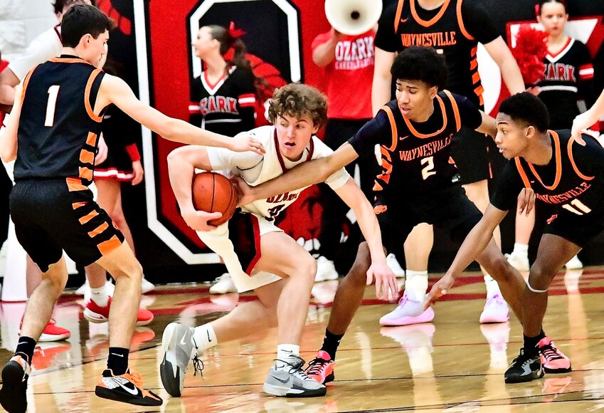 OZARK'S JACK BERRYMAN draws a trio of Waynesville defenders Friday.