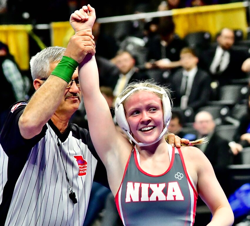 NIXA'S ADDISON HARKINS has her arm raised after winning the Class 2 125-pound state championship.