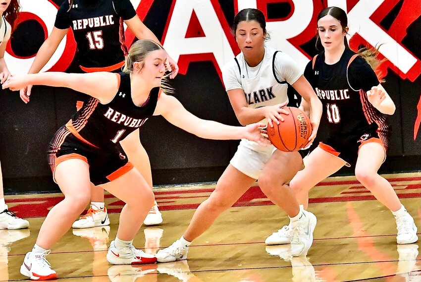 OZARK'S KORI ROUSSELL protects the ball in front of two Republic defenders Thursday.