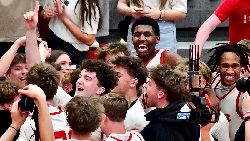 NIXA'S JAISE COMBS celebrates the Eagles' Class 6 District 5 championship with teammates and classmates.