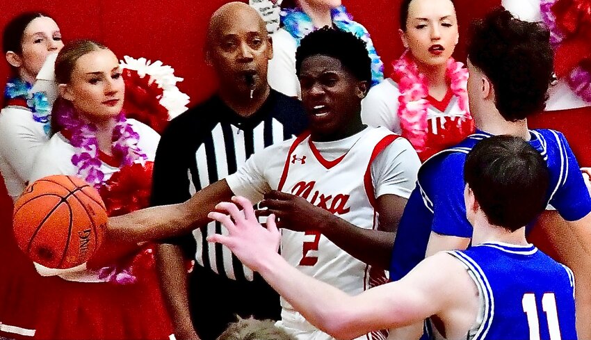 NIXA'S KEIVON FLINT passes in front of a pair of Rockhurst defenders Friday.