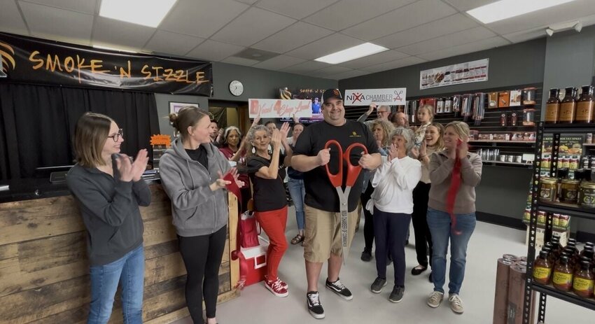 Chris Barr, owner of Smoke N Sizzle, holds up the scissors after cutting the ribbon at the ceremony marking his business’s membership with the Nixa Chamber of Commerce. Smoke N Sizzle is located at 210 N. Massey Blvd., call (417)370-8996, or visit their Facebook page for more information. Photo courtesy of the Nixa Chamber of Commerce.