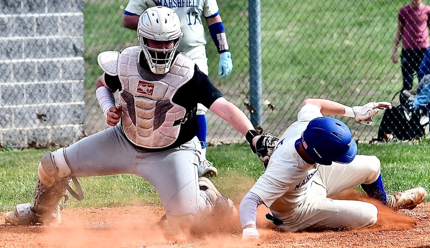 CLEVER'S TALEN SMITH makes a late tag at home plate as a Marshfield runner scores Monday.