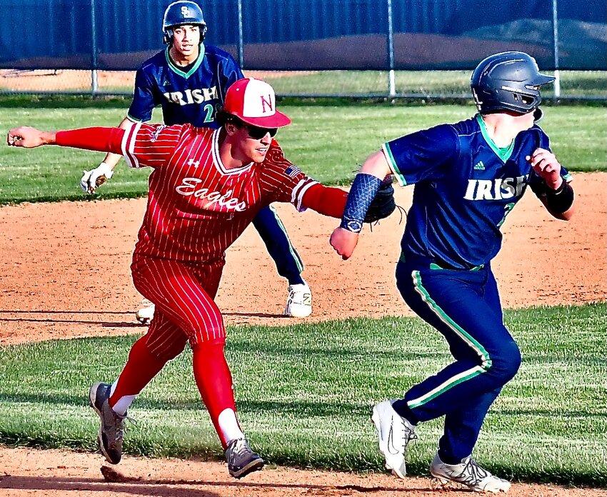 NIXA'S PARKER MANN tags out a Springfield Catholic baserunner in betweeen second base and third base Tuesday.