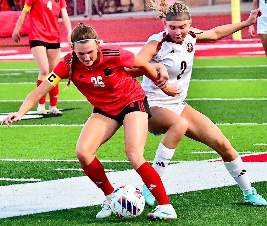 OZARK'S ADDISON SHULER beats a Rogersville player to the ball Wednesday.