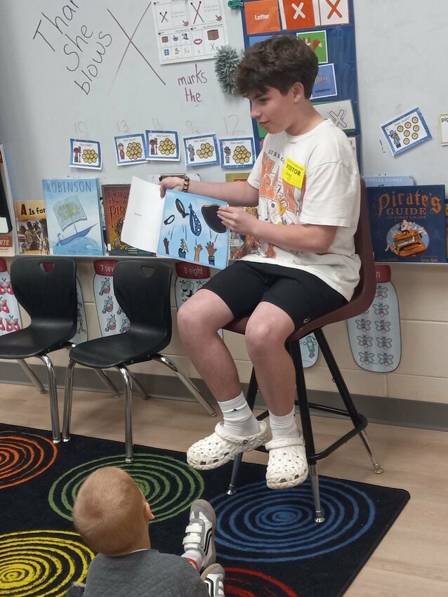 Carter Zoromski, 14, reads his book, PJ Pirate, to the kindergartners in Leigh Berry's class. Photo by Steve Chapman.