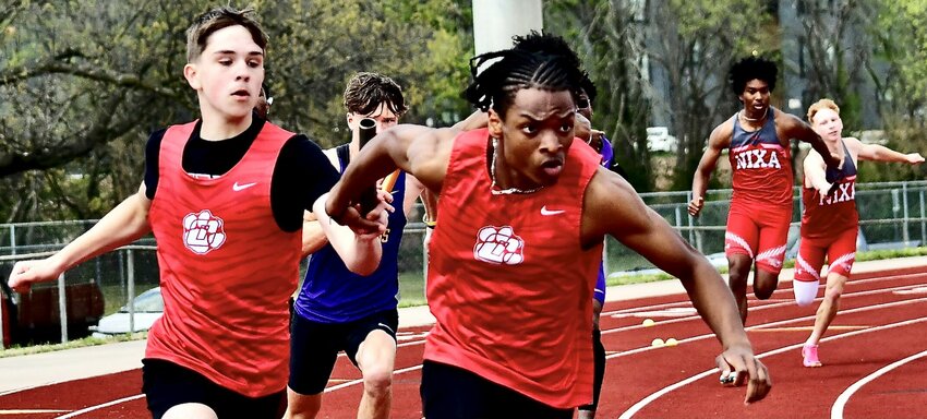 OZARK'S KANNON WILLIAMS receives the baton in the 4 x 200 relay.