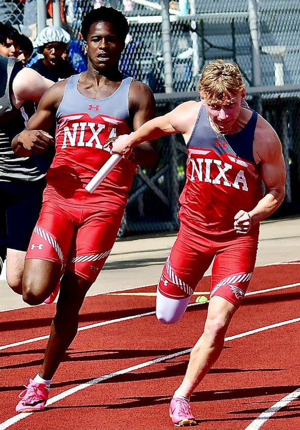 NIXA'S KEIVON FLINT NAD TROY HUFF team up for a exchange in the 4 x 100 relay.