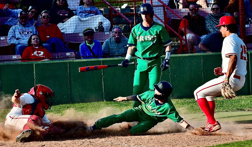 OZARK'S GANNON MILLER applies a late tag of a Catholic baserunner at home plate.