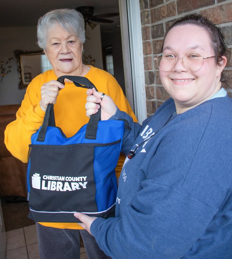 Library patron Harriet S. (left) receives her monthly delivery from Library Outreach Staff member Sam L. (right). Photo courtesy of the Christian County Library.