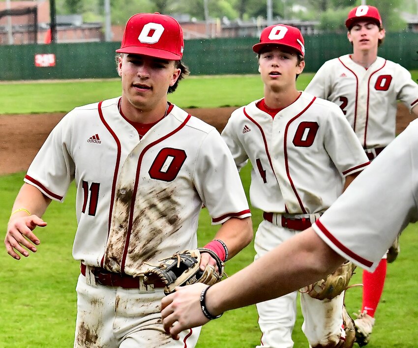 OZARK'S DREW HAYWARD receives a glad hand Thursday ahead of teammates Brody Julian and Marcus Heavin.