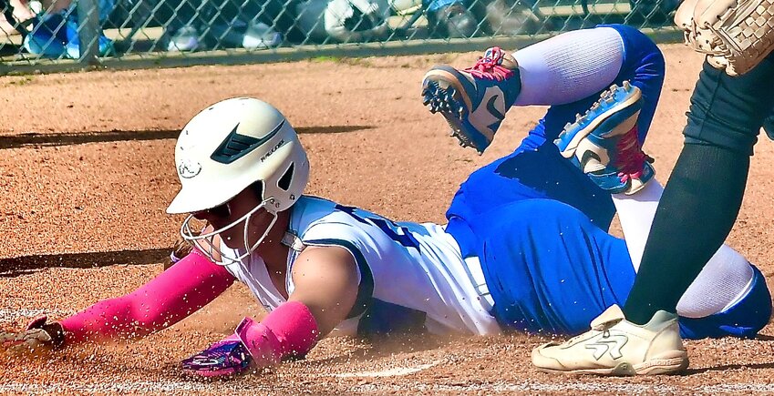 CLEVER'S IZZY HUDAK sides safely across home plate.
