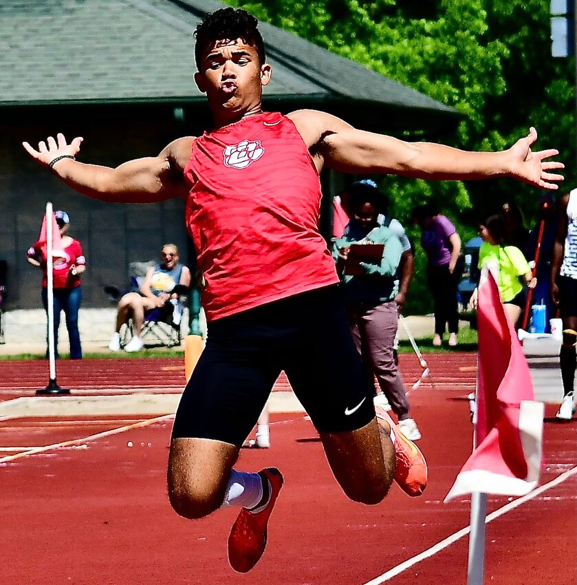 OZARK'S SAM CLARK soars in the long jump.