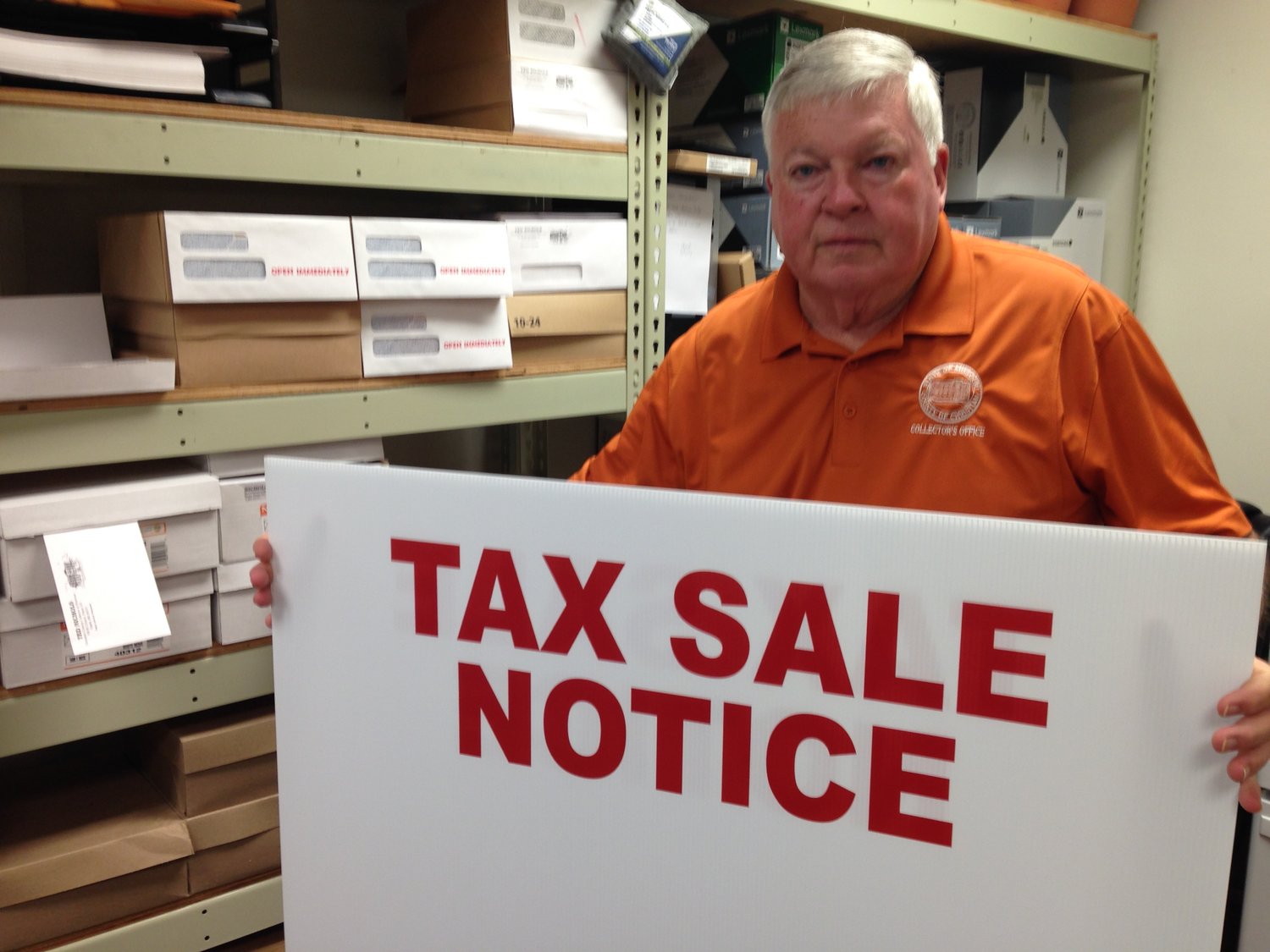 CHRISTIAN COUNTY COLLECTOR OF REVENUE TED NICHOLS shows one of the outdoor signs he and his staff use to post property that is found to be delinquent on personal property tax payments and subject to the collector’s annual tax sale.