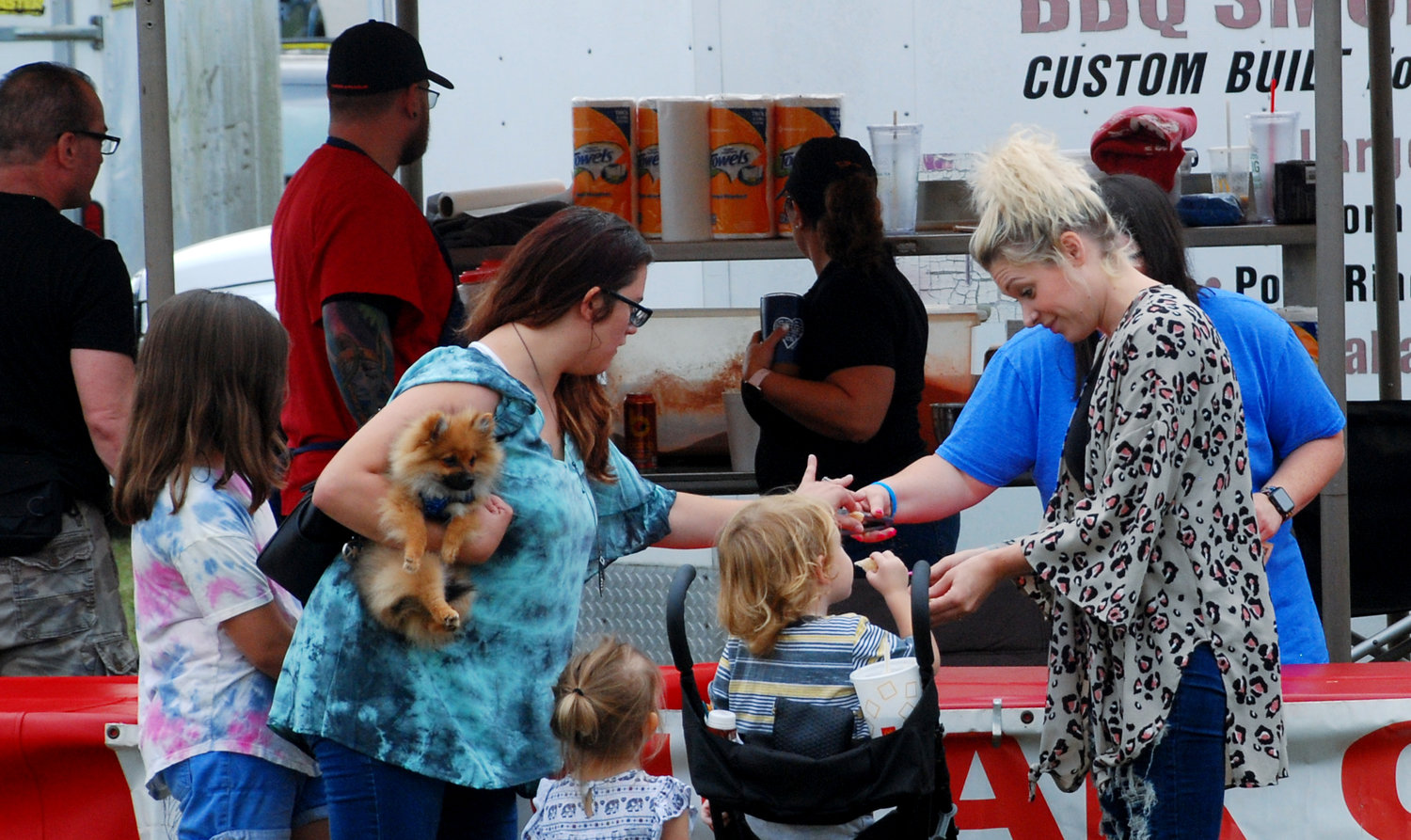 EVERYONE AND THE DOG — A group of ladies and a dog taste test some barbecue at the Ozark Utopia Club’s 47th Annual Ozark Arts and Crafts Show at Finley River Park on Oct. 1.