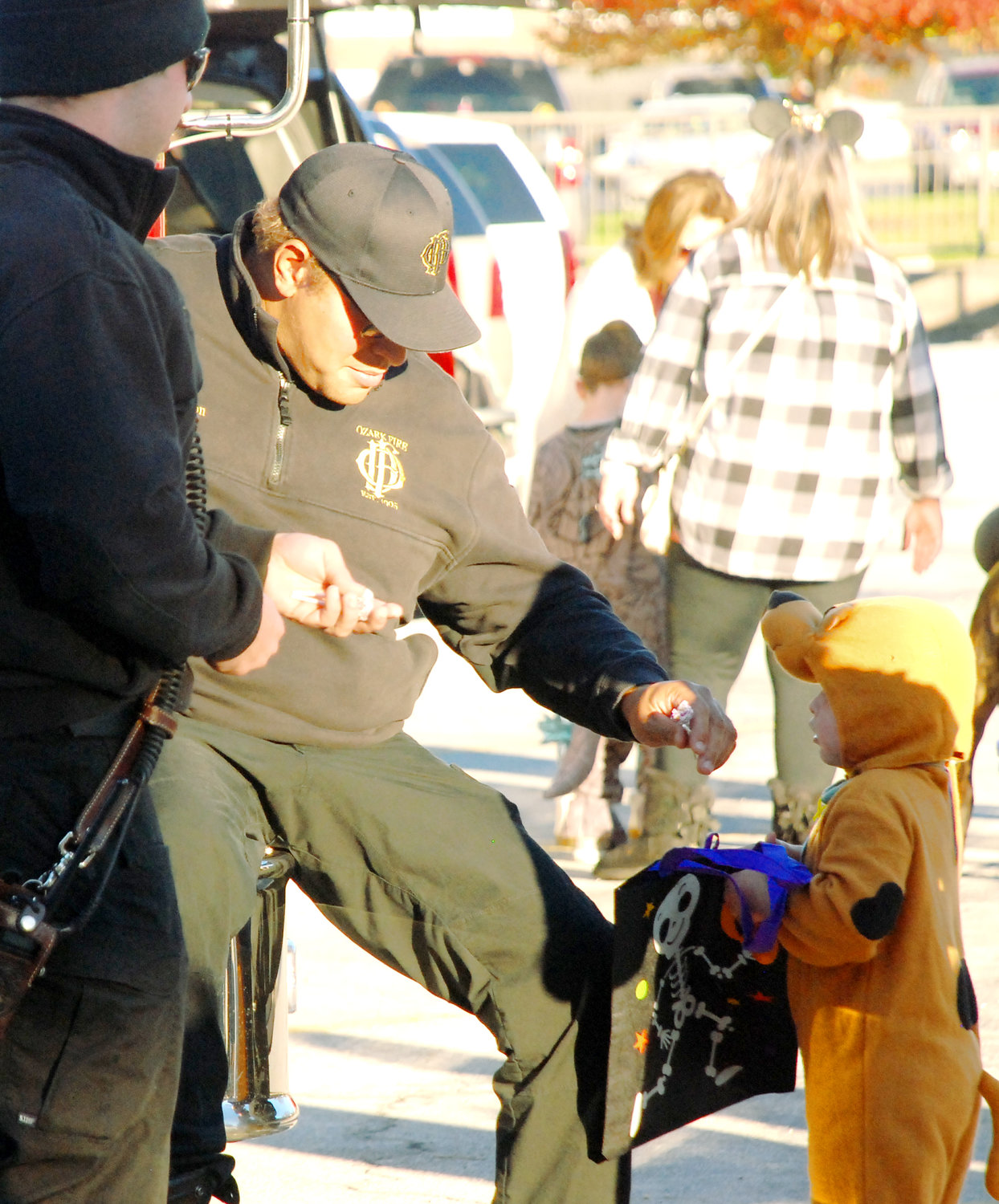 SCOOBY DOO (right) receives a treat from an Ozark firefighter in front of the Ozark police station on Halloween.