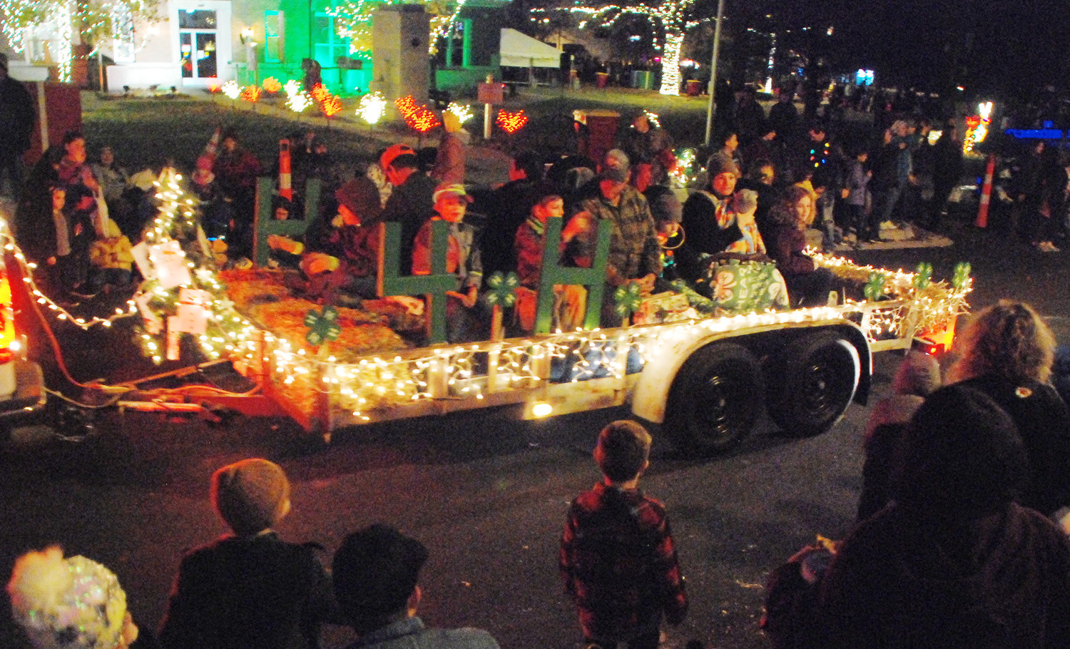 4-H CLUB MEMBERS ride in a parade float down North Second Avenue in Ozark at the end of the Ozark Christmas Parade.