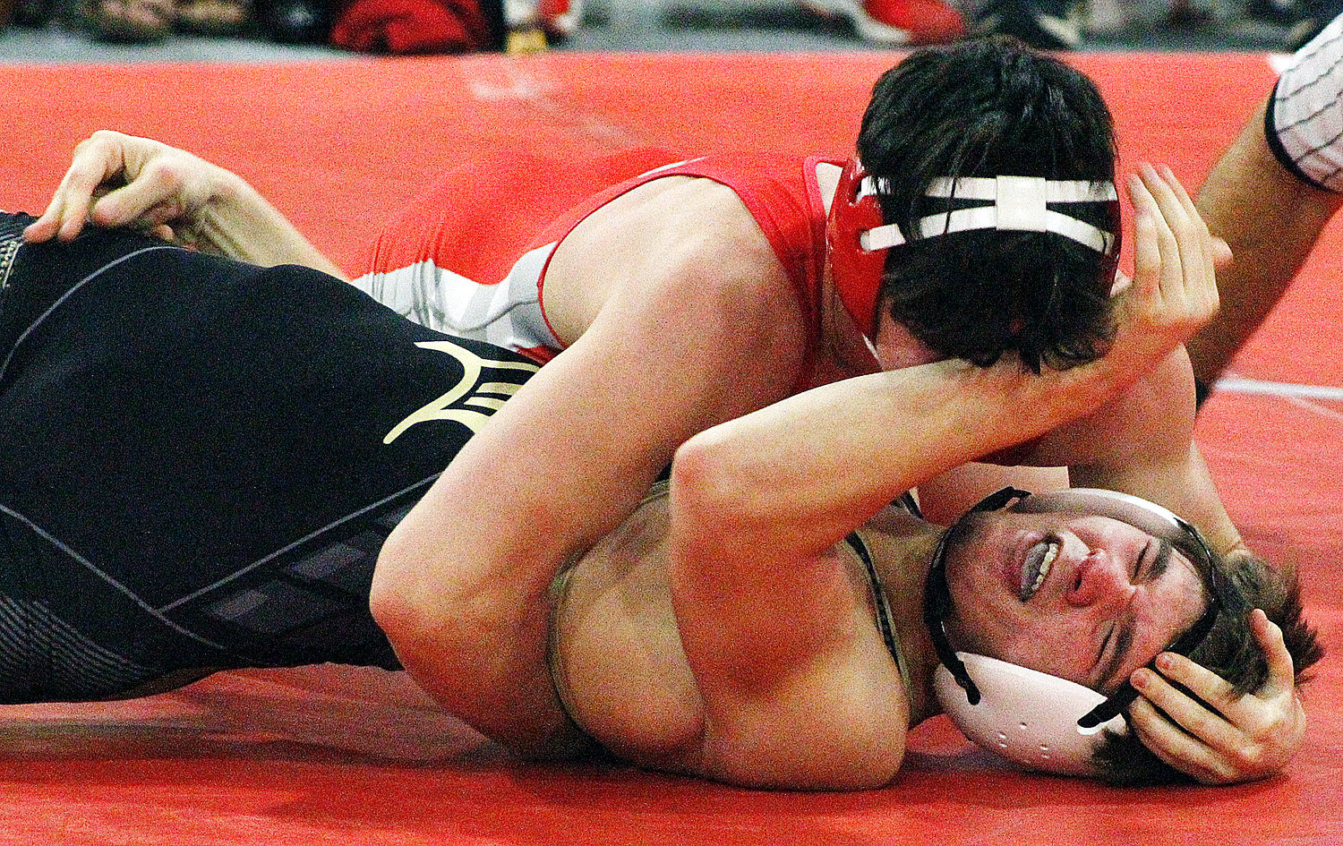 COLE CRAHAN doesn’t let up en route to a pin as his opponent shoves a forearm in his face.