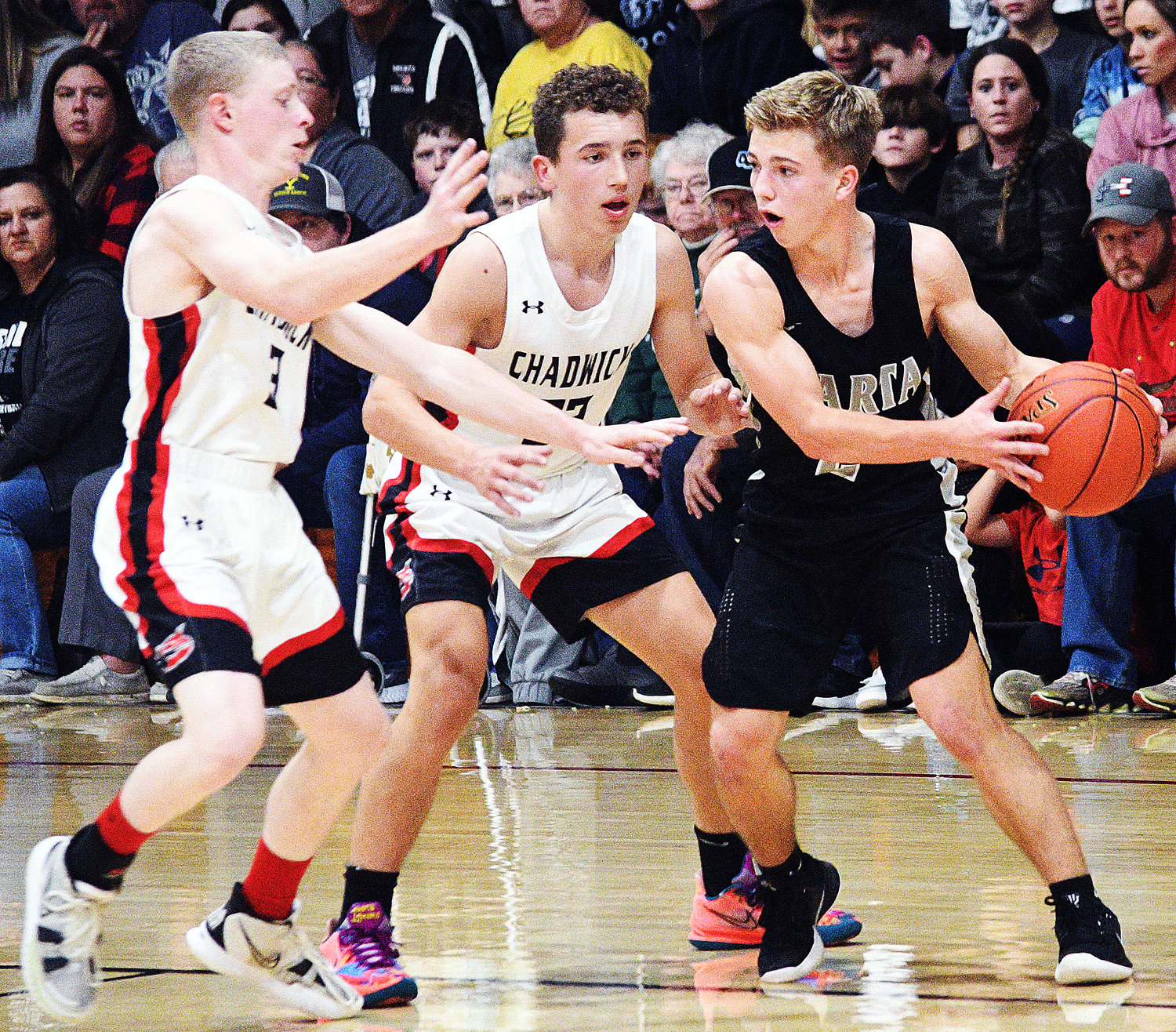 SPARTA’S WALKER LOVELAND looks for room around Chadwick’s Garrett Guerin and Tristan Smith in the teams’ matchup Tuesday.