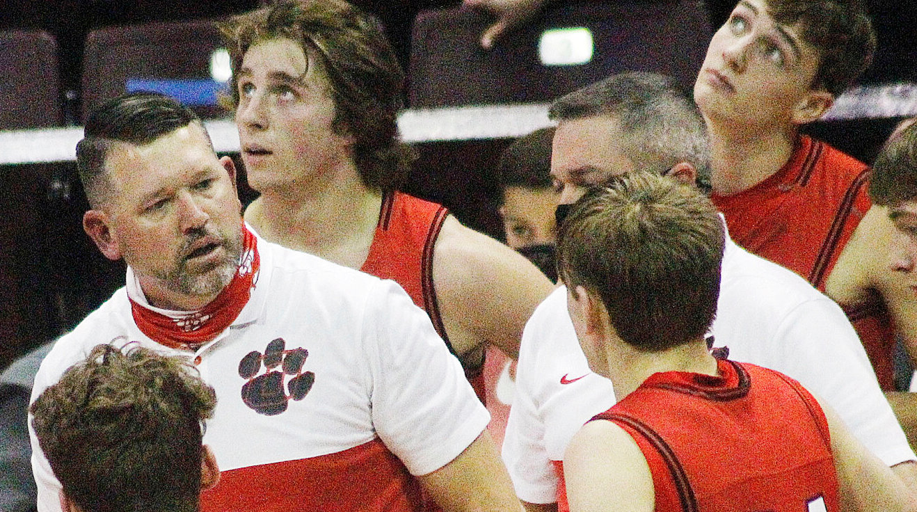 OZARK COACH MARK SCHWEITZER huddles with his players during a game last season.