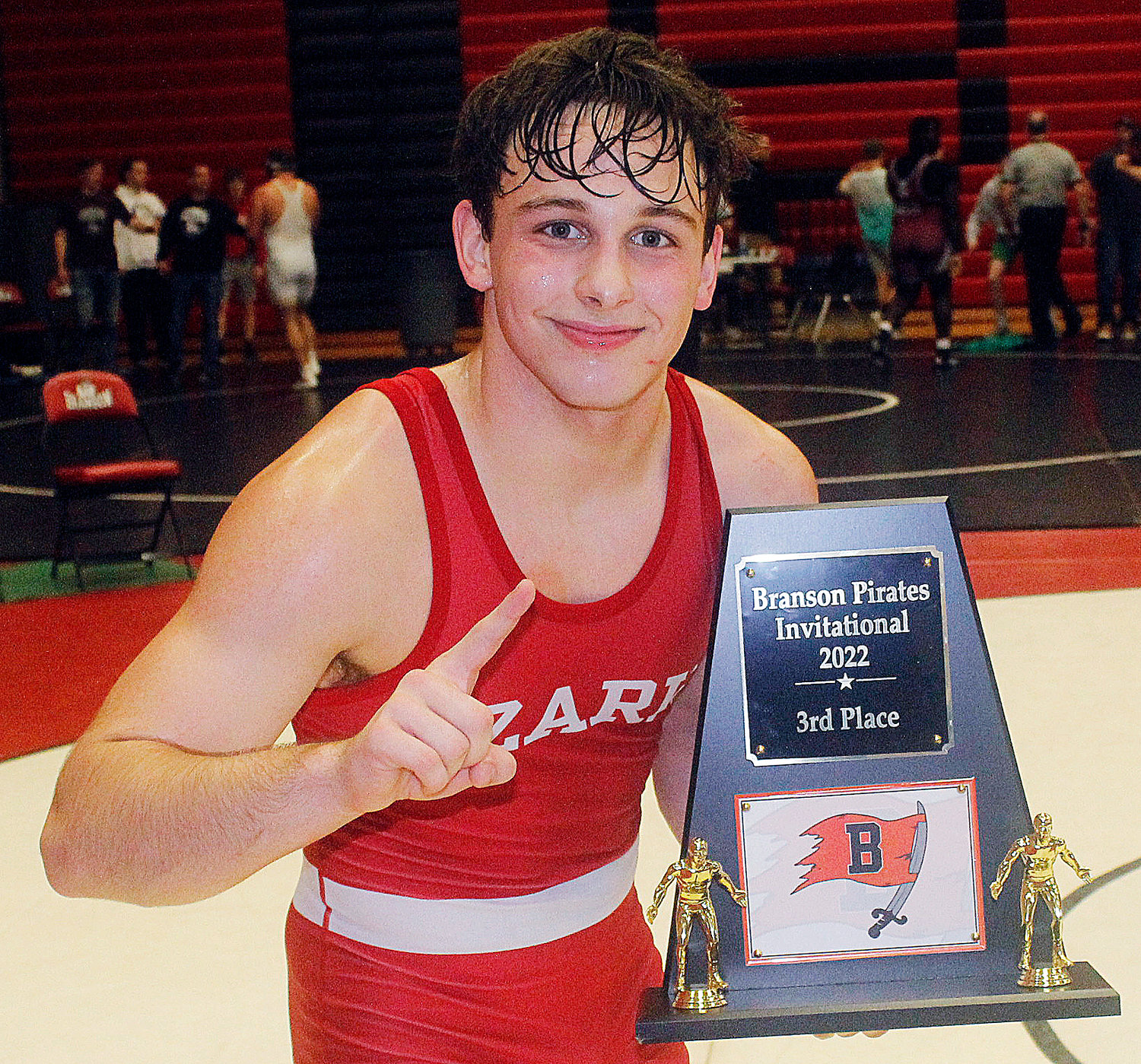 OZARK’S BRAXTON STRICK poses with the Tigers' third-place trophy.