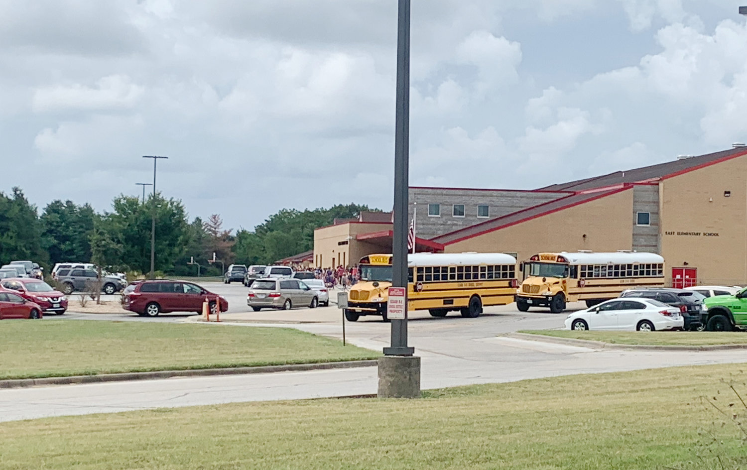 Car lines and bus lines are formed for student dismissal outside of Ozark East Elementary School on a spring day in 2021.