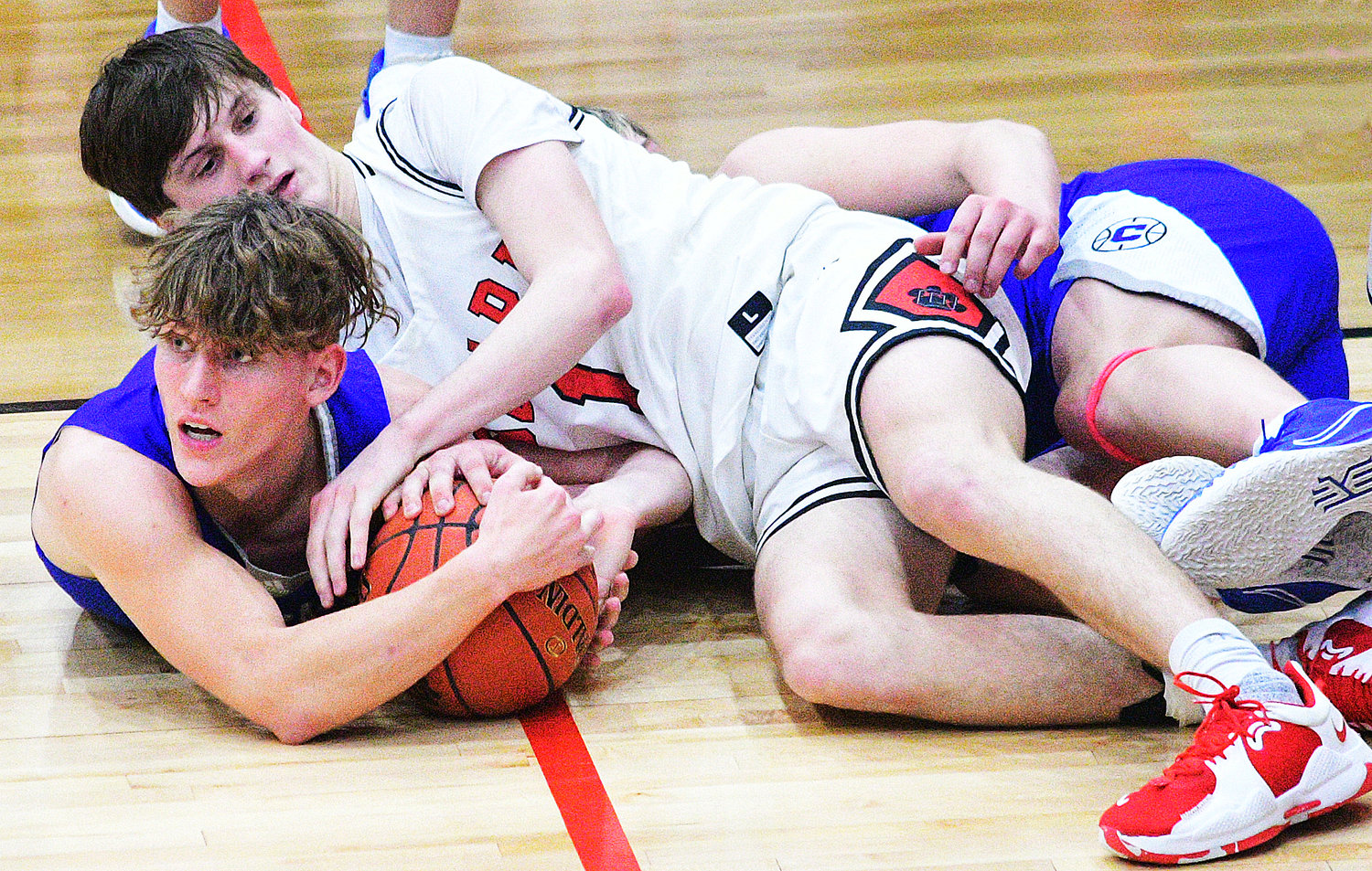 OZARK’S JACE WHATLEY and a Carthage player hit the floor while batting for the ball Friday.