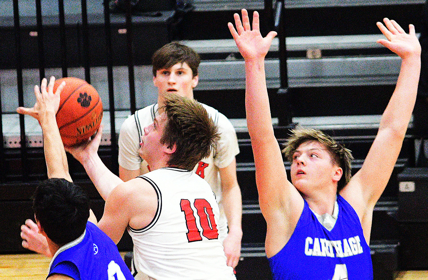 TYLER HARMON shoots in between two Carthage players.