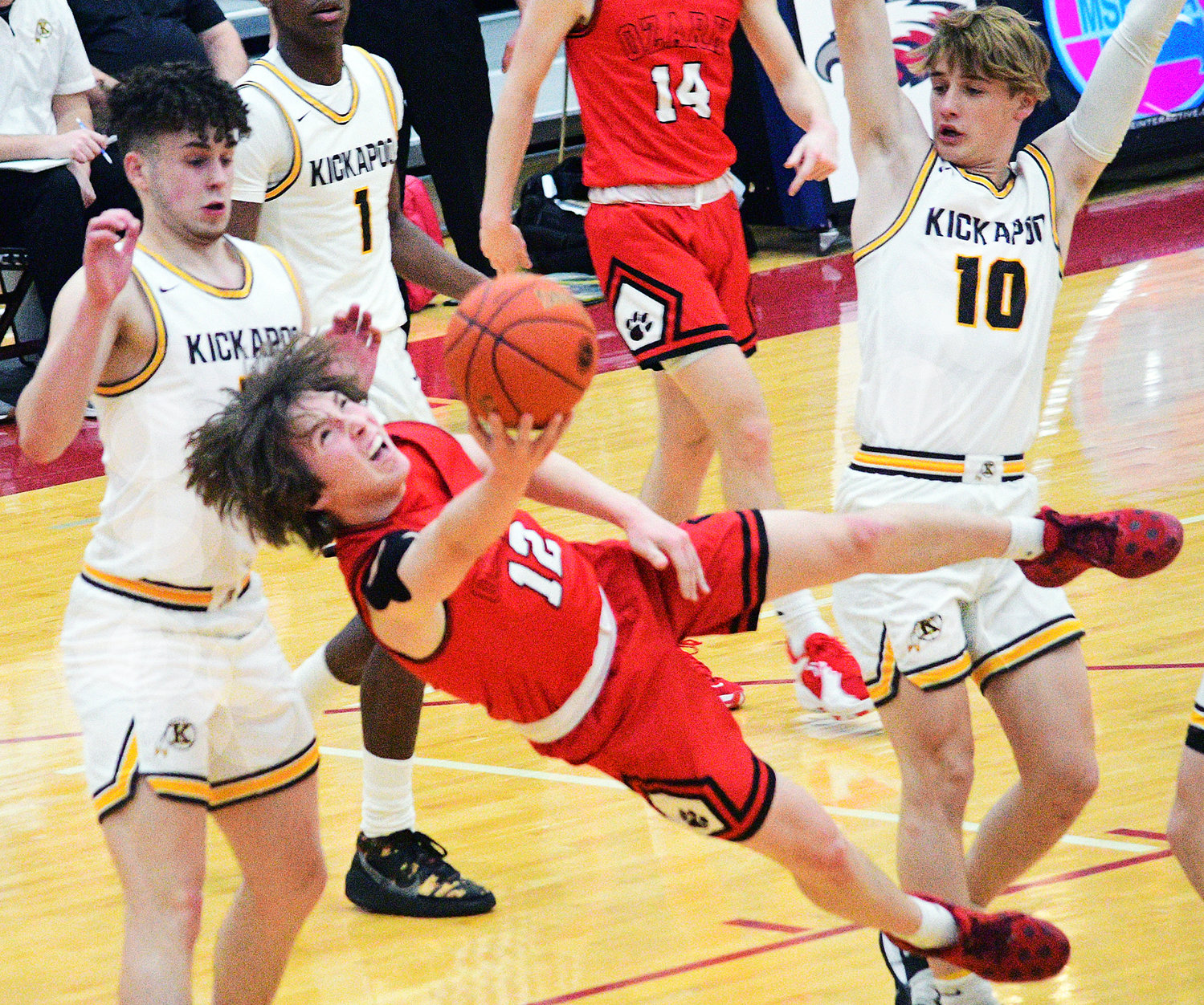 OZARK’S COLTON BALLARD puts up a shot in between two Kickapoo defenders Wednesday in Class 6 District 5 semifinal action.