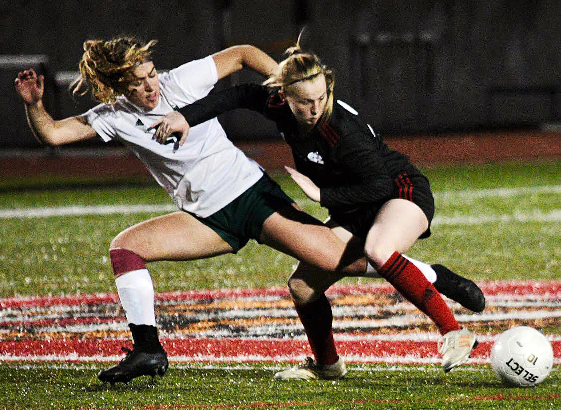 OZARK’S MOLLY RUSHING battles for control of the ball with a Catholic player.