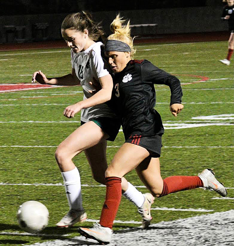 OZARK’S MADISON MORGAN and a Catholic player chase after a loose ball.